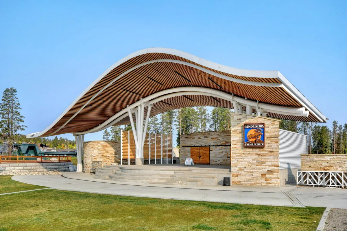 An outdoor stage area with a curved roof and inviting stone facade sets the scene for community events, concerts, and gatherings, signifying opportunities for group bonding beyond the villa itself.