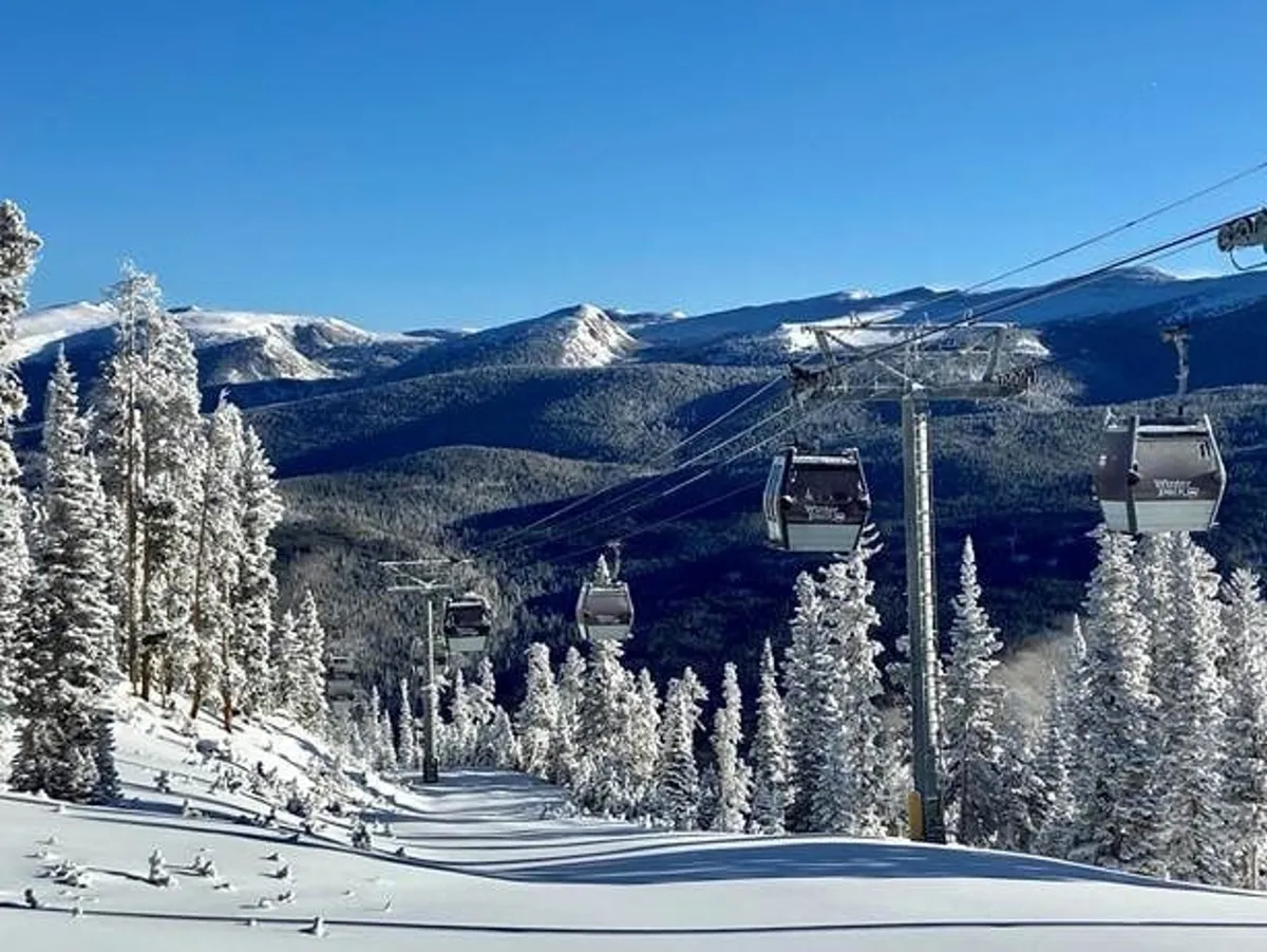 A breathtaking exterior winter scene featuring gondola lifts ascending over a snow-covered landscape, with pine trees and distant mountains under a serene sky. The image evokes adventure and the excitement of alpine activities.
